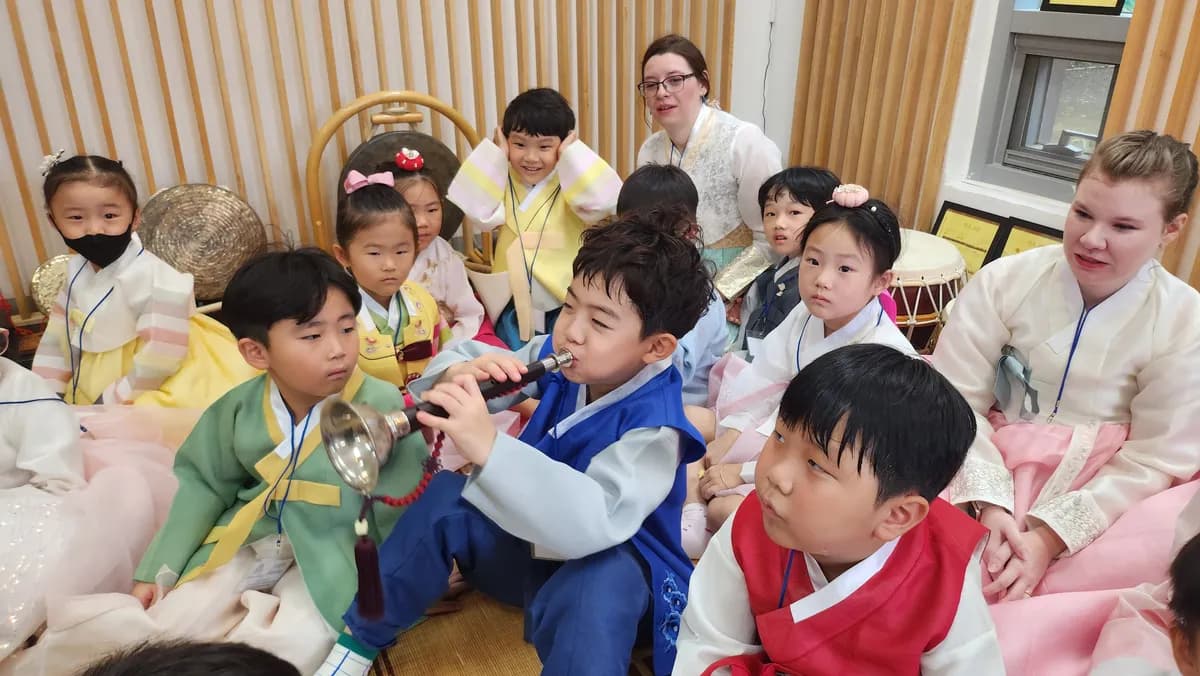 태평소를 불고 있는 유치원 수강생들과 같이 즐거워하는 아이들 사진